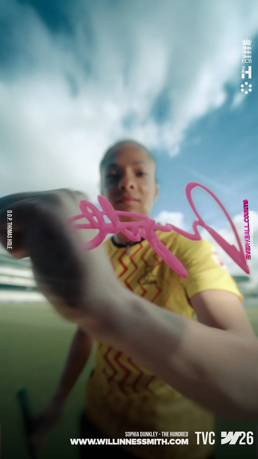 Sophia Dunkley signing a pink autograph across the lens · The Hundred