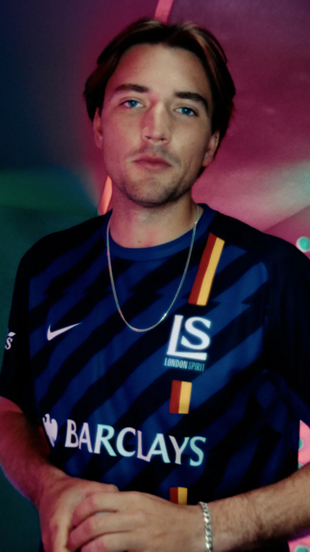 A London Spirit player against a wash of pink and green light · The Hundred