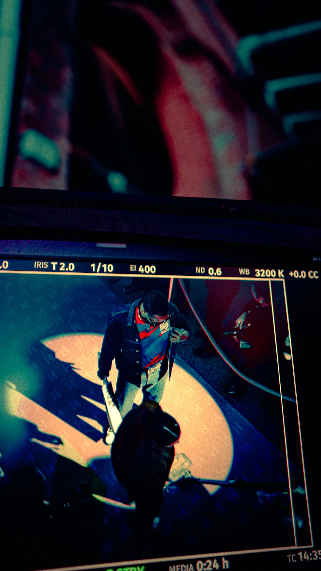 An overhead camera monitor framing a guitarist on the pitch · The Hundred