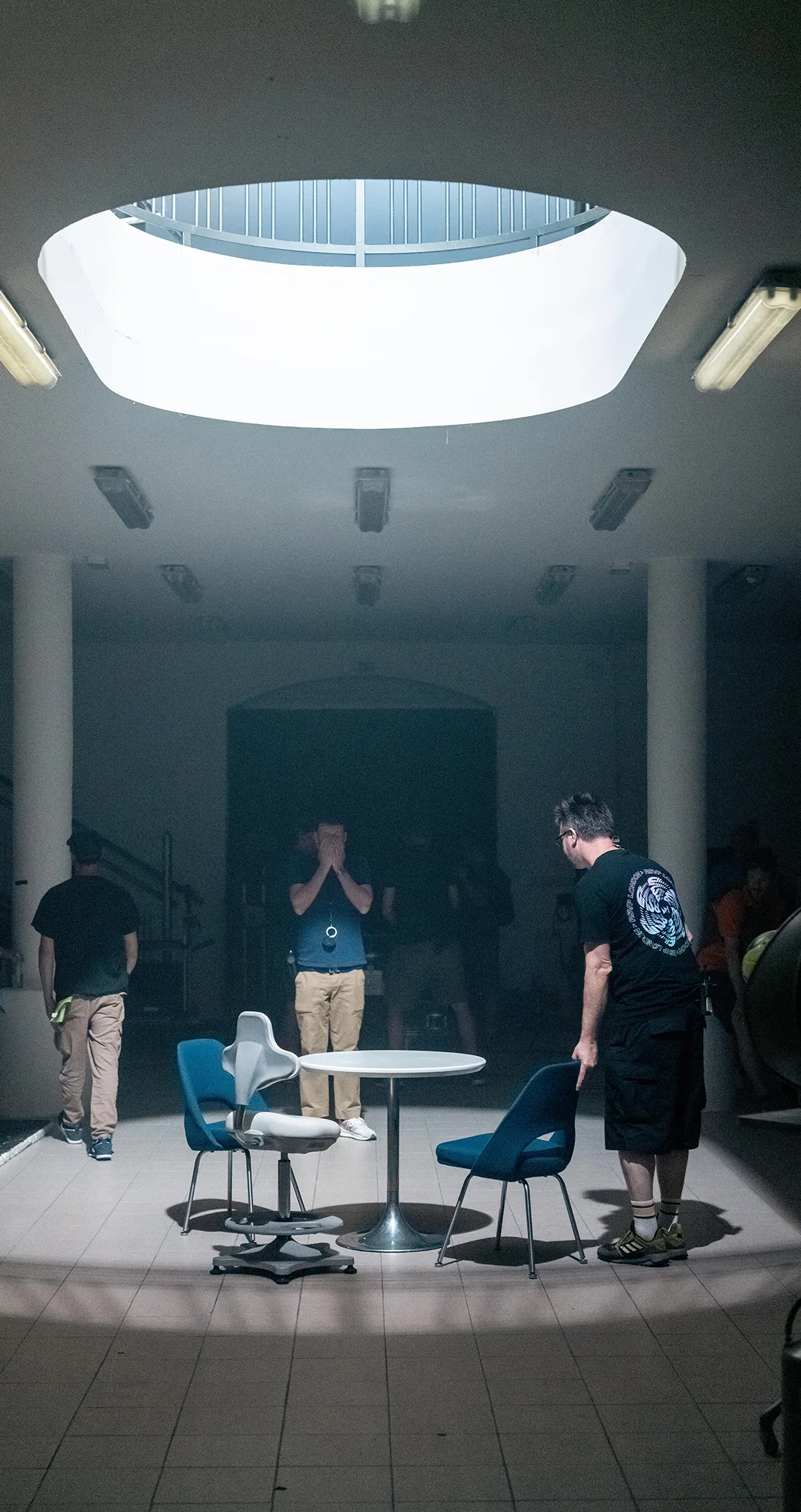 Crew resetting beneath the skylight in the same retro room