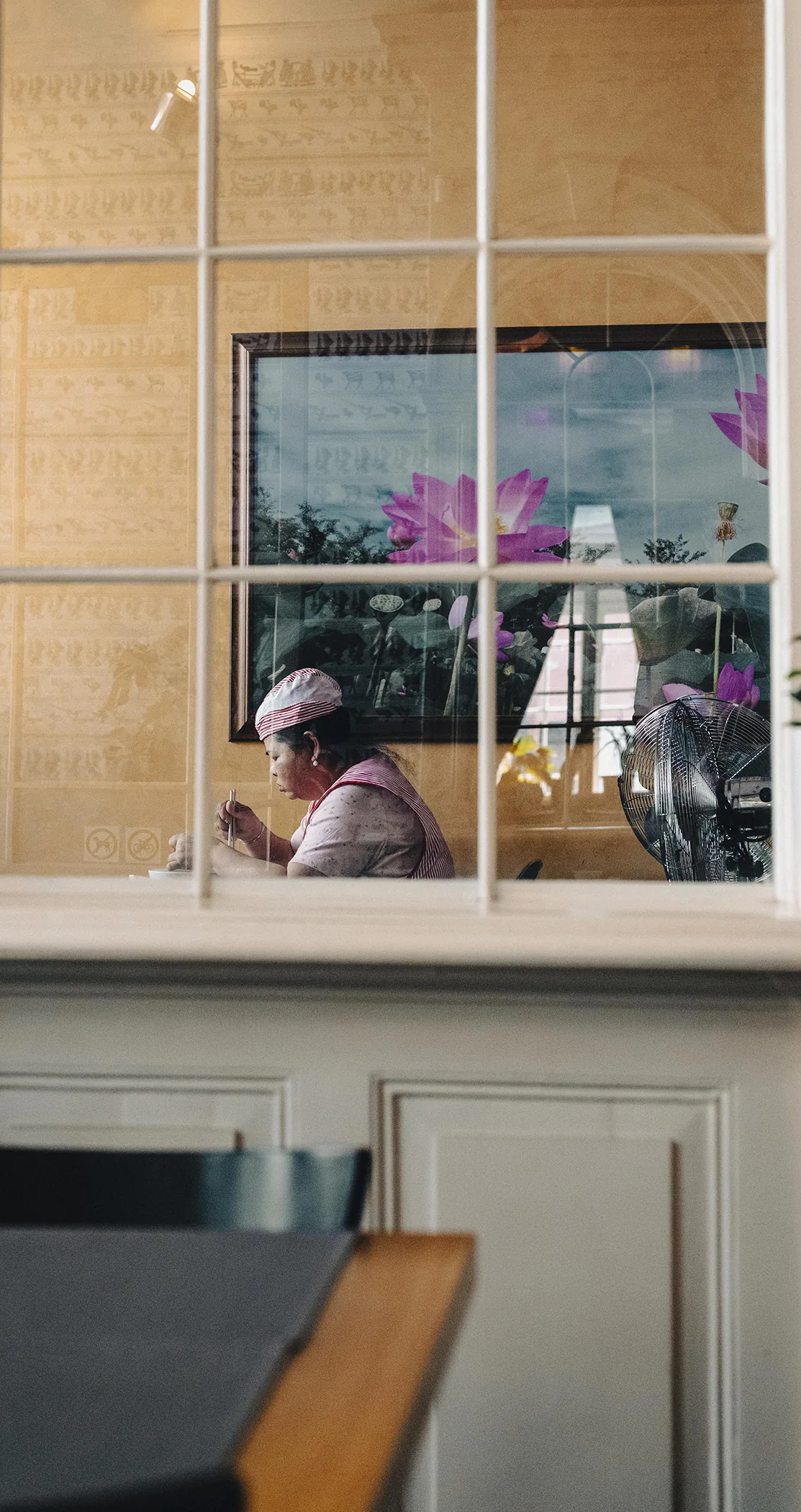 A woman eating at a window table, seen through a café window